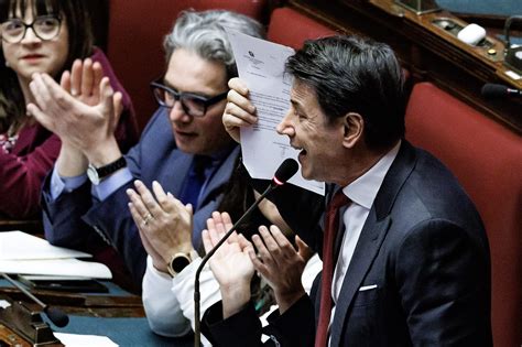 Giuseppe Conte in un momento di riflessione o in intervista, magari con un accenno simbolico alla sua devozione per Padre Pio