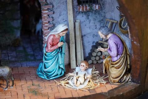 Illustrazione dettagliata di un presepe tradizionale italiano con muschio e personaggi che svolgono mestieri.
