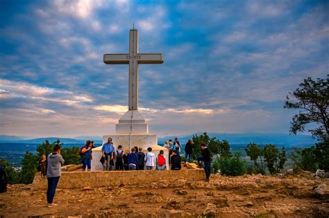 Foto di gruppo di pellegrini che pregano sul Križevac a Medjugorje all'alba
