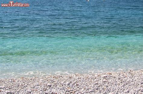Foto dettagliata della sabbia e ghiaia della Spiaggia di Santa Maria con l'acqua cristallina