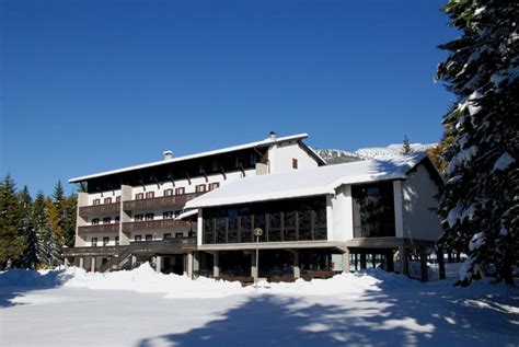 Foto esterna della Casa Santa Maria a Folgaria con le montagne trentine sullo sfondo