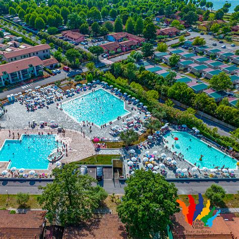 Foto della piscina esterna del Camper Village con ombrelloni e lettini