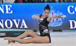 Foto di una ginnasta che esegue un esercizio di ginnastica ritmica con un attrezzo.