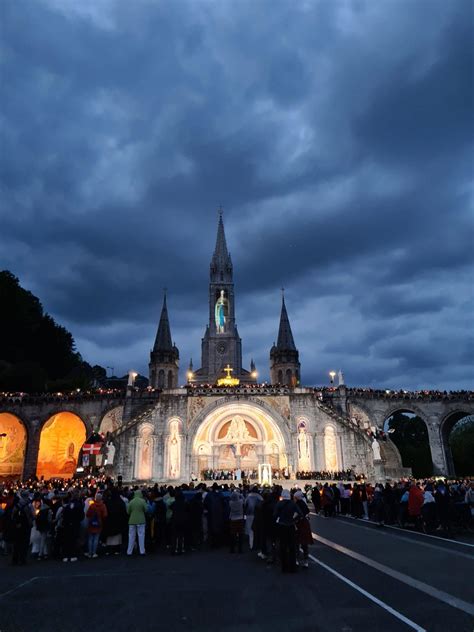 Foto di pellegrini a Lourdes durante una processione con le fiaccole