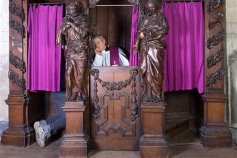 Sacerdote che ascolta in confessionale, con un'atmosfera serena e riflessiva.
