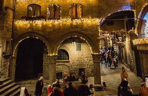 Scorcio di un vicolo siciliano illuminato durante il periodo natalizio con musicisti tradizionali