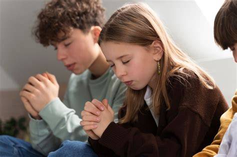 Famiglia che prega insieme, con le mani giunte o una persona che benedice gli altri membri della famiglia