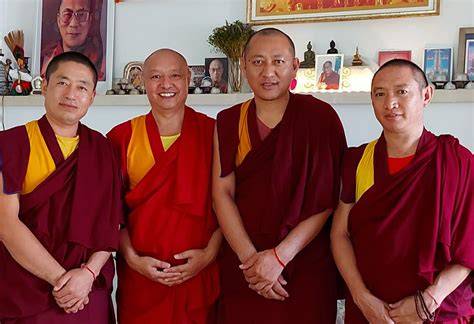 Monaci tibetani in abiti vinaccia e rossi durante una cerimonia