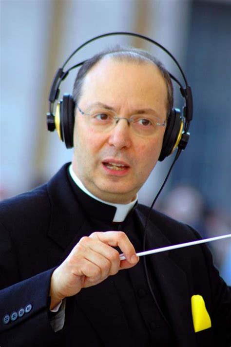 Foto di Monsignor Marco Frisina mentre dirige un coro