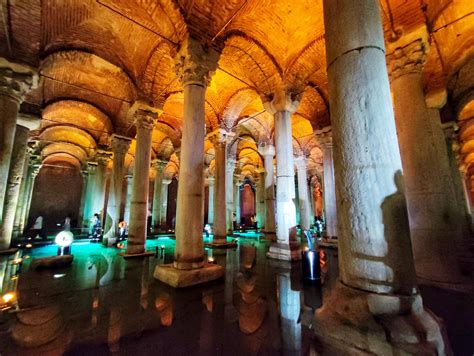 Veduta interna della Cisterna Basilica con colonnati illuminati e specchio d'acqua