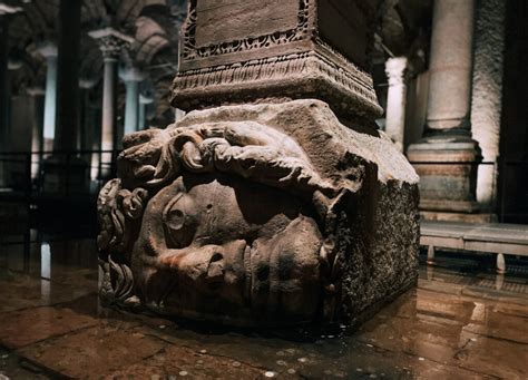 Dettaglio della testa di Medusa capovolta alla base di una colonna