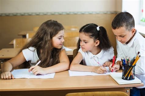 Foto di bambini e ragazzi in un doposcuola che studiano con i tutor