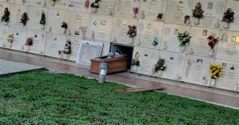 Foto di un sacerdote che benedice le tombe in un cimitero durante la Commemorazione dei Defunti