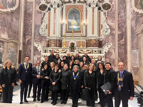 Foto di un gruppo di fedeli che recita il Rosario, con un'atmosfera di devozione e unità