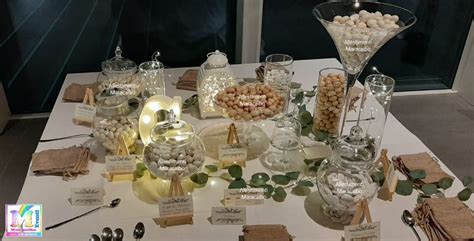 Tavolo della confettata di battesimo con vari contenitori e decorazioni a tema