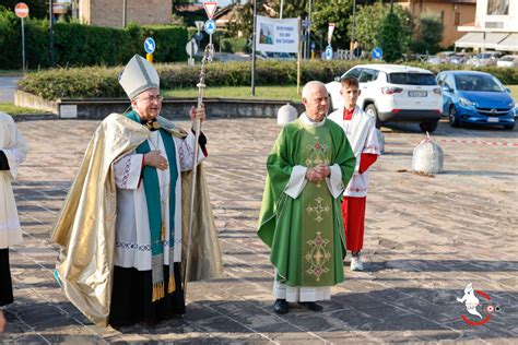 Cerimonia di ingresso di un nuovo parroco nella comunità, con fedeli e autorità ecclesiastiche e civili.