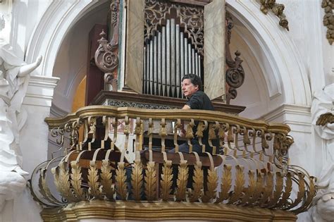 Foto di un organo liturgico in una chiesa, con un tecnico al lavoro