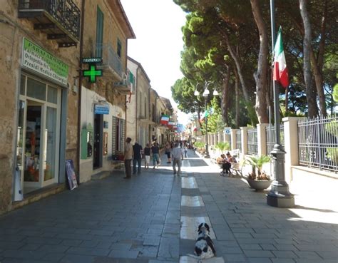 Foto panoramica del Corso Senatore Andrea Matarazzo a Santa Maria di Castellabate, con persone che passeggiano e negozi lungo la via.