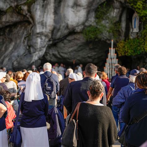 Volontari UNITALSI che assistono persone con disabilità durante un pellegrinaggio a Lourdes