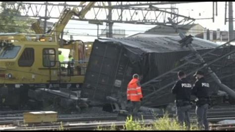 Illustrazione di un treno merci uscito dai binari a causa di un'alluvione