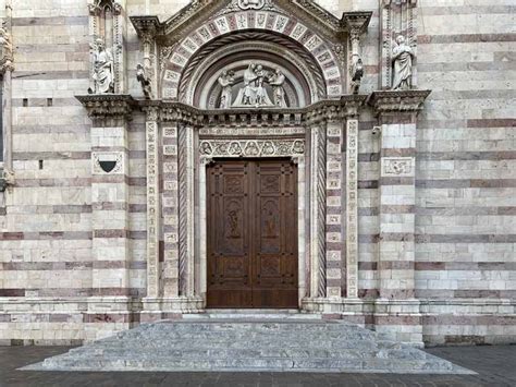 Foto di un troccolante che bussa tre volte sul portone di una chiesa