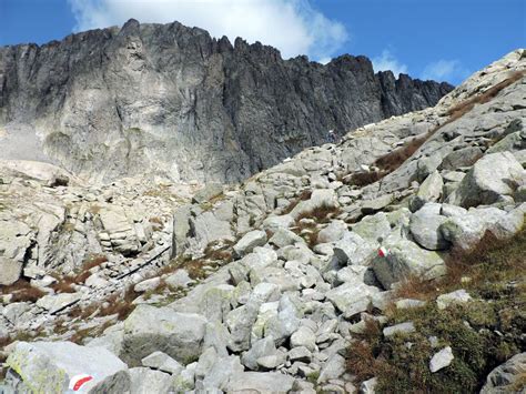 Pellegrini che salgono lungo il sentiero sassoso del Monte della Croce (Križevac), passando accanto a una delle stazioni della Via Crucis.