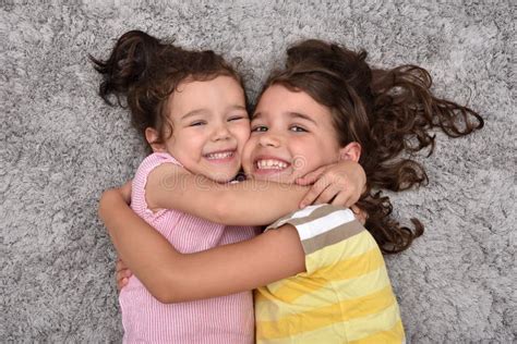 Foto di due sorelle che si abbracciano e sorridono felici