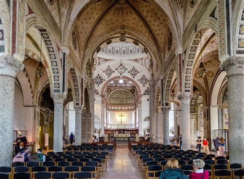 Interno della chiesa di Santa Maria delle Grazie durante la celebrazione eucaristica, con fedeli e affreschi.