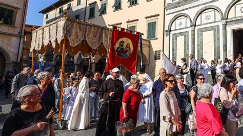 Persone in costumi tradizionali che si preparano per la processione, con dettagli degli abiti.