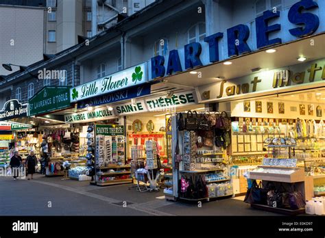 Via commerciale con negozi di souvenir religiosi a Lourdes