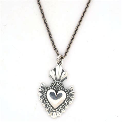 Dettaglio di una collana Ex Voto artigianale in oro con incisioni a mano