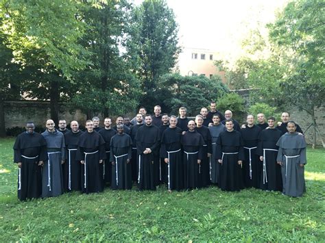 fotografia di un gruppo di frati francescani interagendo con giovani in un contesto informale