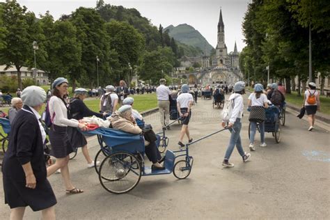 Foto di gruppo di volontari del Santuario di Lourdes che assistono i pellegrini
