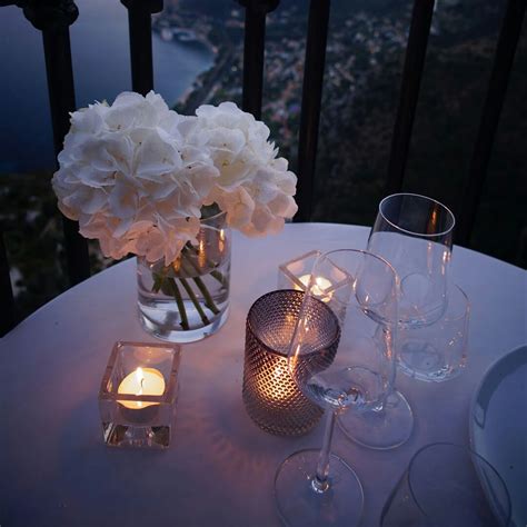 Un tavolo apparecchiato per una cena romantica, con candele e fiori.