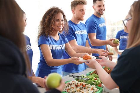 Foto di volontari che distribuiscono cibo in una mensa per i poveri