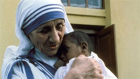 Madre Teresa mentre assiste un bambino povero a Calcutta