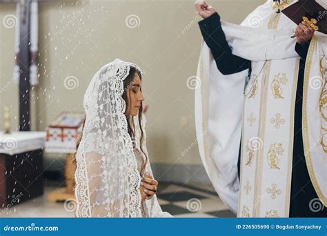 Sacerdote che benedice la bara con acqua santa e incenso durante un funerale cattolico