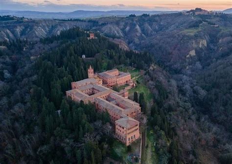 veduta panoramica dell'Abbazia di Monte Oliveto Maggiore tra i calanchi e i cipressi