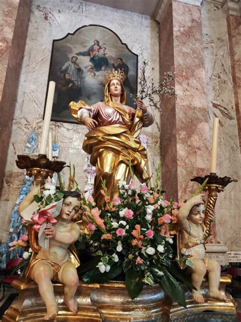 Statua della Madonna dei Fiori con un fascio di fiori freschi ai suoi piedi.