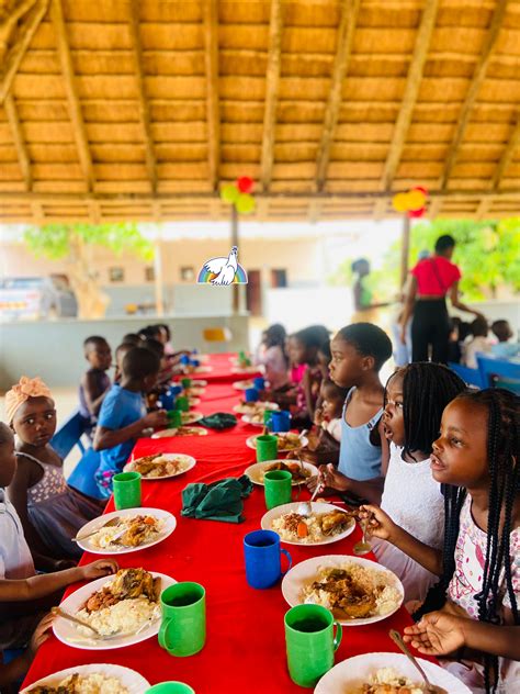 Volontari e missionari che interagiscono con i bambini in un centro missionario in Mozambico, durante attività di gioco