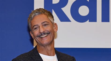 Ritratto fotografico di Rosario Fiorello che sorride, in un'atmosfera intima e rilassata.
