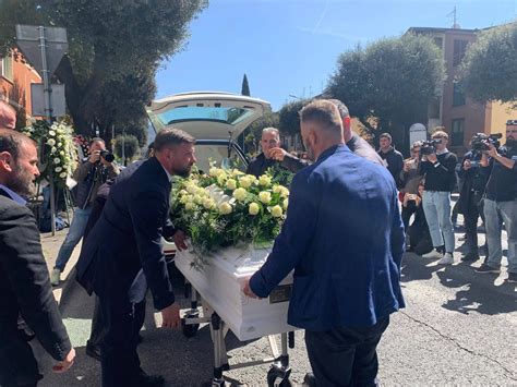 Foto di un corteo funebre o di una chiesa con persone all'esterno, rispettando la sensibilità
