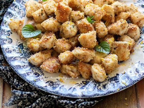 Tavola imbandita con pollo fritto, bocconcini di mozzarella, arancini, patatine e birre