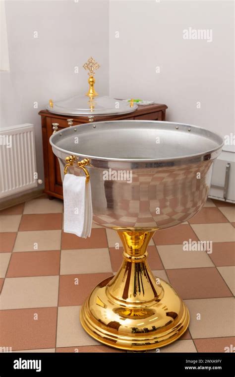 Fontana battesimale con acqua in una chiesa, illuminata da luci soffuse
