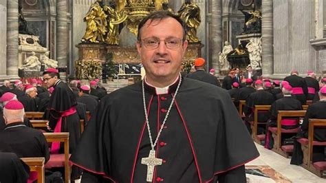 Foto di Monsignor Giuseppe de Candia sorridente mentre saluta i fedeli o riceve gli auguri di compleanno in un contesto parrocchiale
