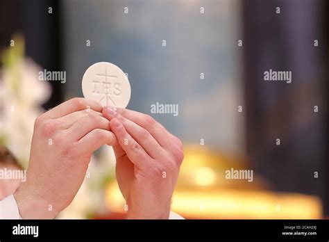foto del sacerdote che spezza l'ostia all'altare durante la Messa