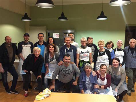 Foto di gruppo di volontari e ospiti in una casa di accoglienza