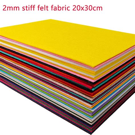 Tavola con diversi fogli di feltro colorato, forbici e colla per lavori di artigianato
