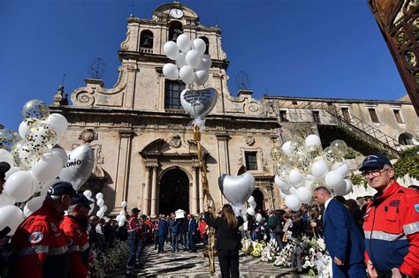 Immagine di una cerimonia funebre con palloncini bianchi