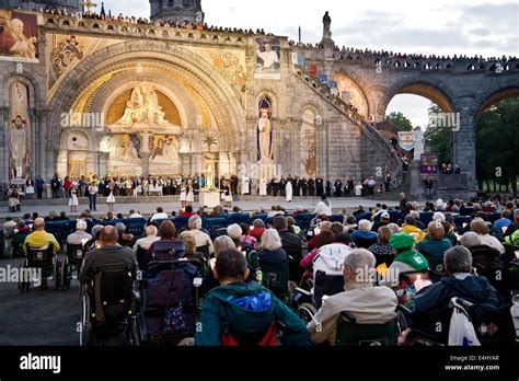 Santuario di Lourdes al tramonto con persone in preghiera